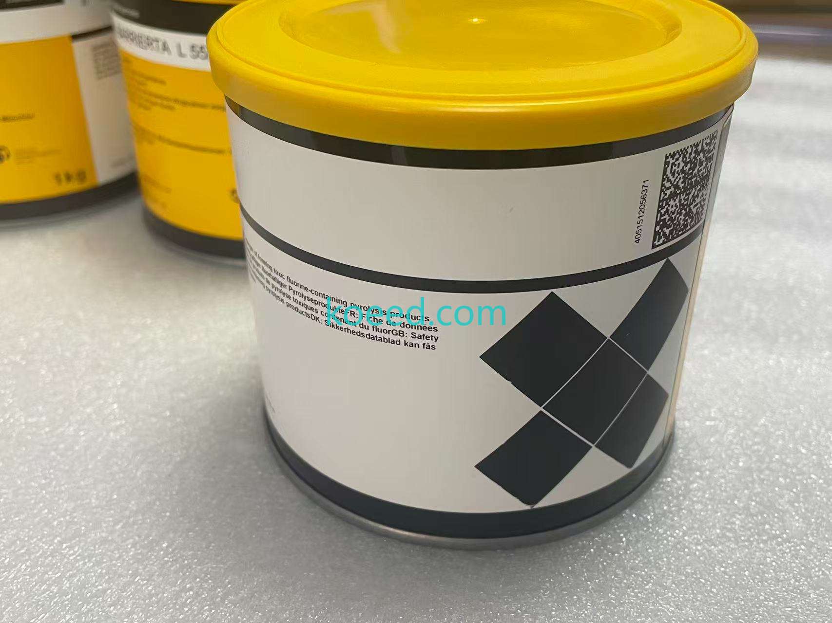 Closed yellow-lidded tub with printed wraparound label and multilingual safety wording; the contents are not visible.