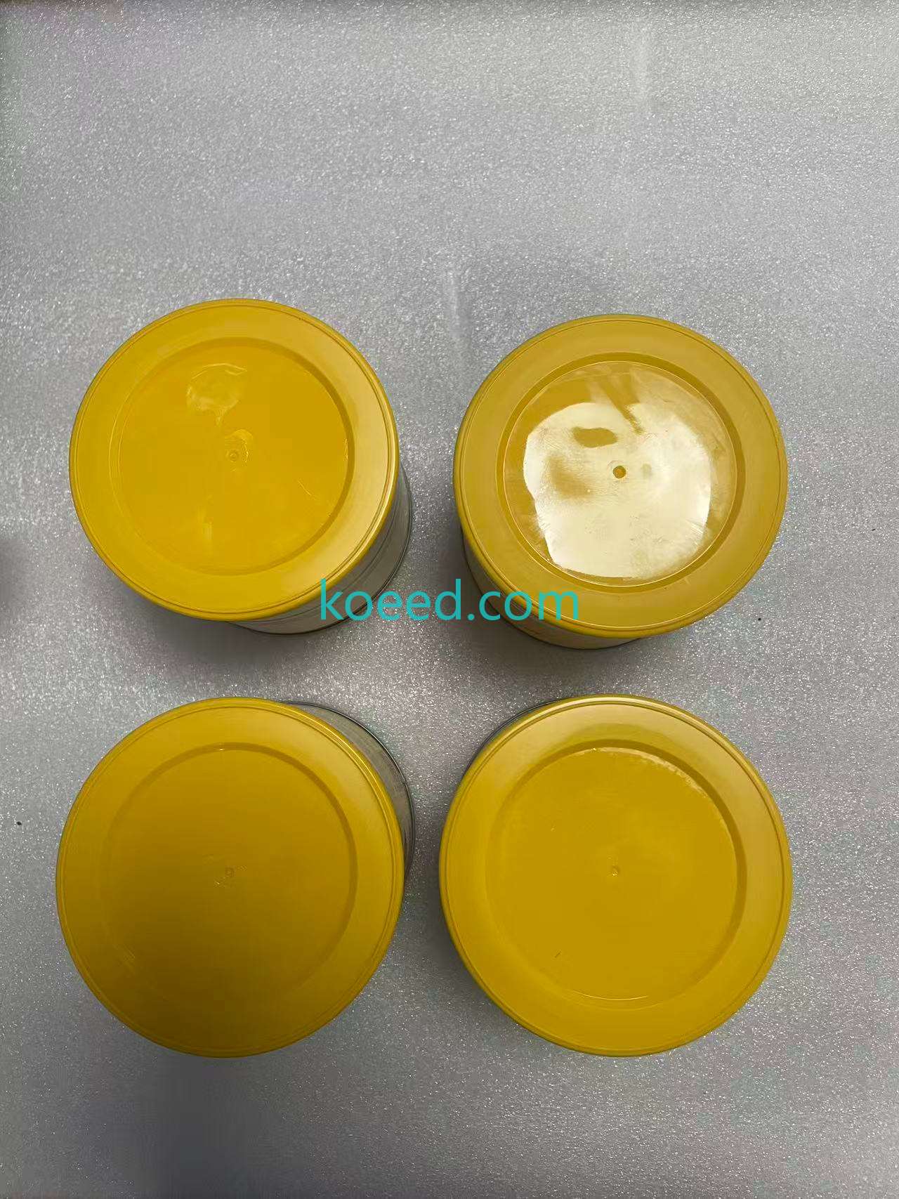 Four closed tubs viewed from above, each with a yellow lid.