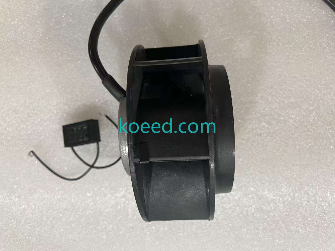 Side profile of the black impeller and motor housing, with cable leads and the rectangular component behind it; dimensions are not measured.